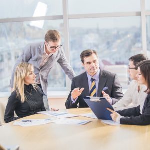 Group of successful business partners in casual communicating at meeting in office